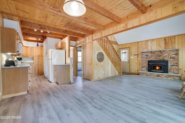 unfurnished living room featuring stairway, light wood-style flooring, beam ceiling, wood ceiling, and wooden walls