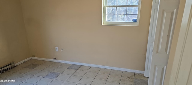 washroom featuring light tile patterned floors, baseboards, baseboard heating, and laundry area