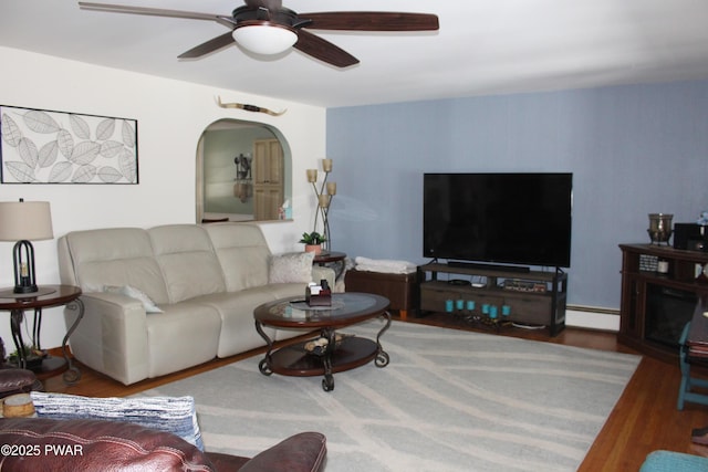 living room featuring a baseboard heating unit, wood-type flooring, and ceiling fan