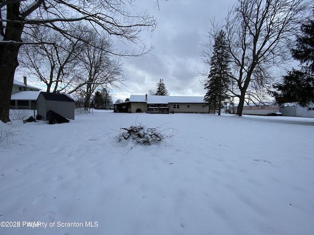 snowy yard with a storage unit