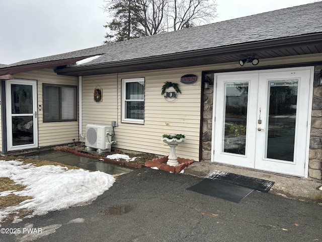 view of exterior entry with french doors and ac unit