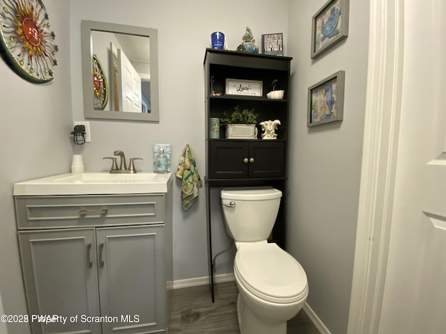 bathroom featuring vanity, hardwood / wood-style floors, and toilet