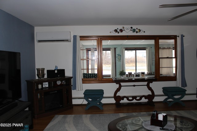 living area with hardwood / wood-style flooring and a wall mounted air conditioner