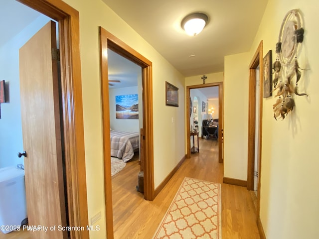 corridor with light hardwood / wood-style floors