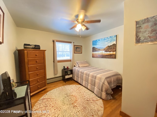 bedroom featuring a baseboard heating unit, light hardwood / wood-style flooring, and ceiling fan