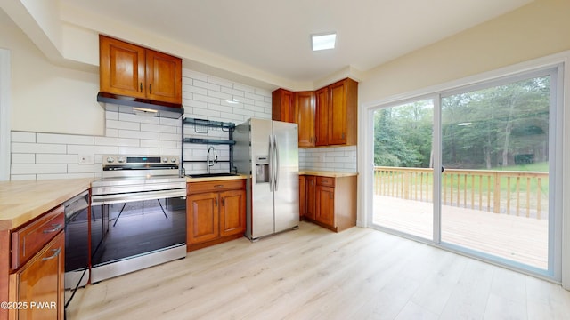 136 Heaters Hill Rd, Matamoras, PA 18336 - kitchen featuring stainless steel appliances, under cabinet range hood, brown cabinets, light wood-style flooring, and tasteful backsplash