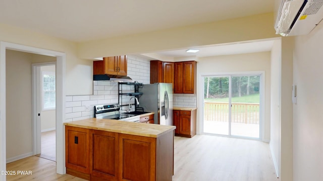 136 Heaters Hill Rd, Matamoras, PA 18336 - kitchen featuring appliances with stainless steel finishes, under cabinet range hood, light wood-type flooring, tasteful backsplash, and brown cabinets