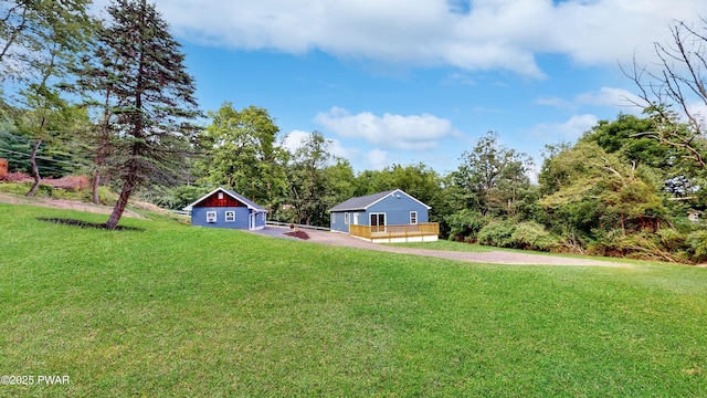 136 Heaters Hill Rd, Matamoras, PA 18336 - view of grassy yard featuring a detached garage, a deck, driveway, and an outdoor structure