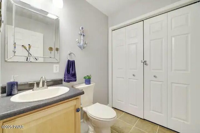 bathroom featuring vanity, tile patterned floors, toilet, and a closet