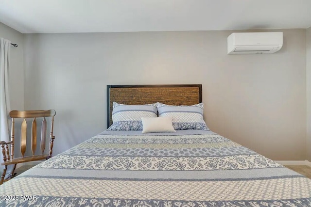 carpeted bedroom featuring baseboards and a wall mounted AC