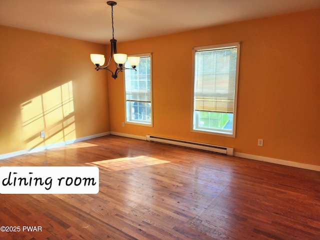 empty room with wood-type flooring, baseboard heating, and a chandelier