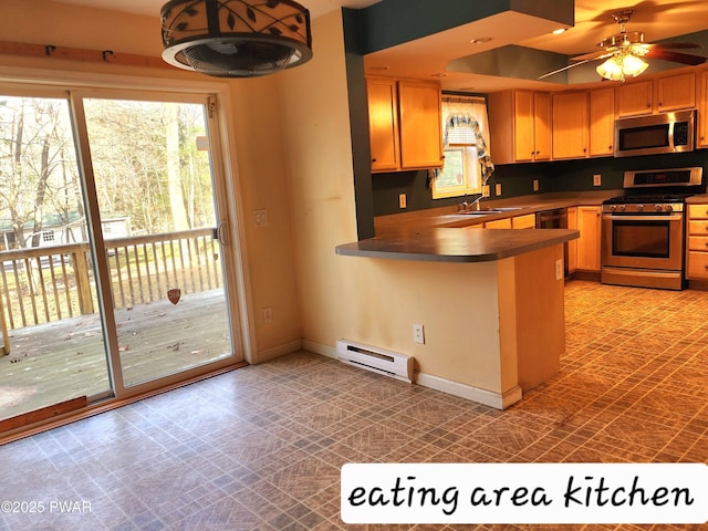 kitchen with kitchen peninsula, appliances with stainless steel finishes, ceiling fan, sink, and a baseboard radiator