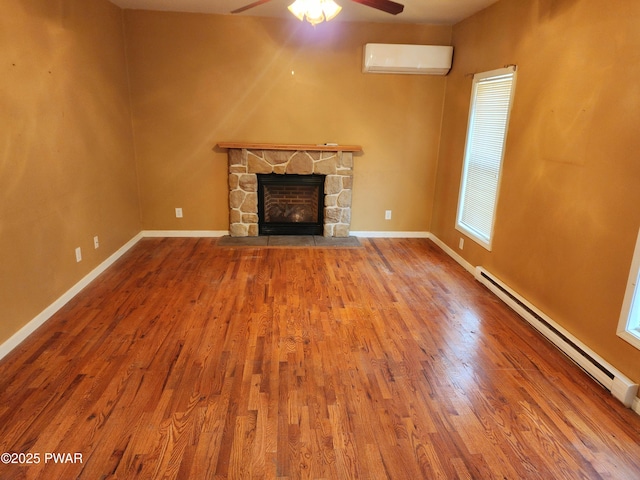 unfurnished living room featuring an AC wall unit, ceiling fan, wood-type flooring, and a baseboard heating unit