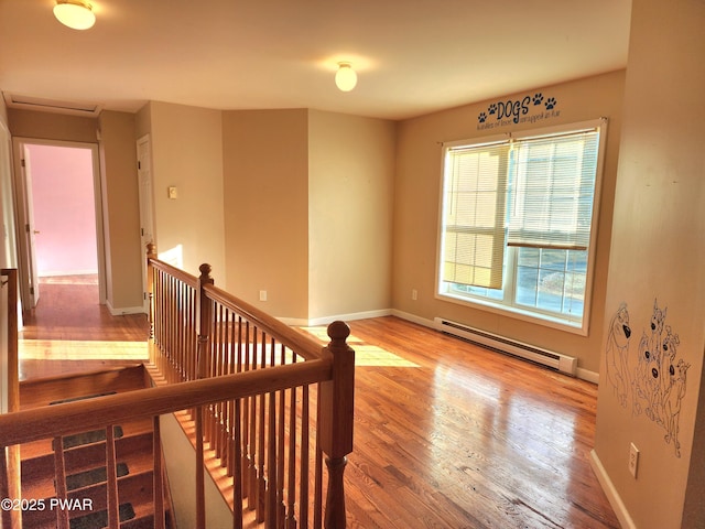 stairs featuring hardwood / wood-style floors and a baseboard heating unit