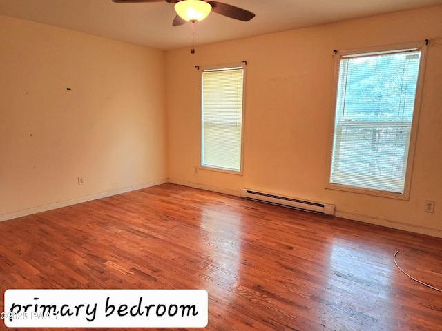 empty room featuring hardwood / wood-style floors, ceiling fan, and a baseboard radiator