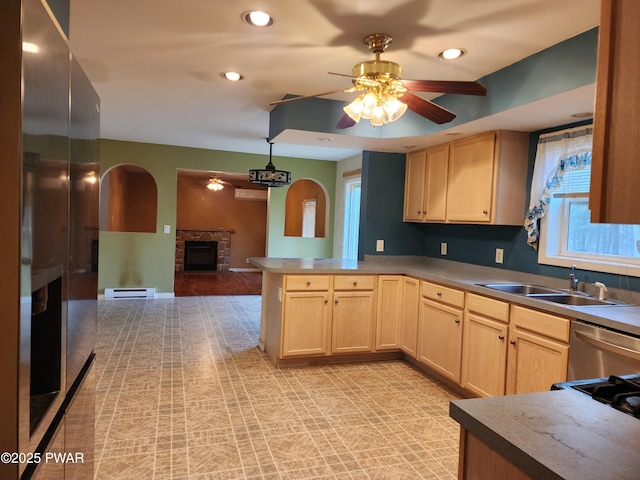 kitchen featuring kitchen peninsula, light brown cabinets, and sink