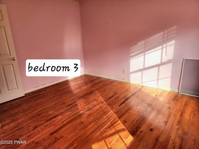 unfurnished room with wood-type flooring