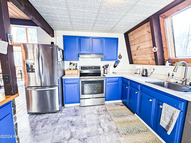 176 Fawn Lake Dr, Hawley, PA 18428 - kitchen with stainless steel appliances, blue cabinetry, under cabinet range hood, a sink, and light countertops