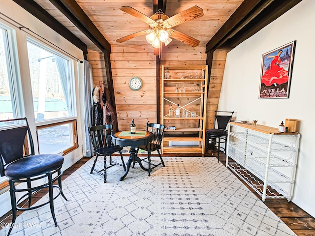 176 Fawn Lake Dr, Hawley, PA 18428 - dining space featuring wooden ceiling with exposed beams, wooden walls, wood finished floors, a ceiling fan, and baseboards