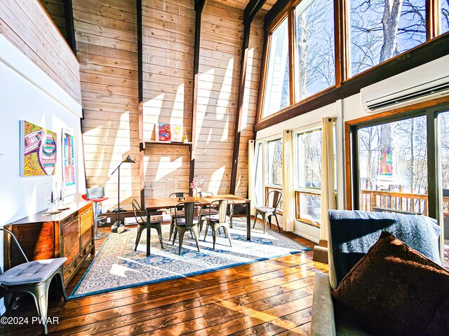 176 Fawn Lake Dr, Hawley, PA 18428 - dining area featuring wood walls, wood-type flooring, and a high ceiling