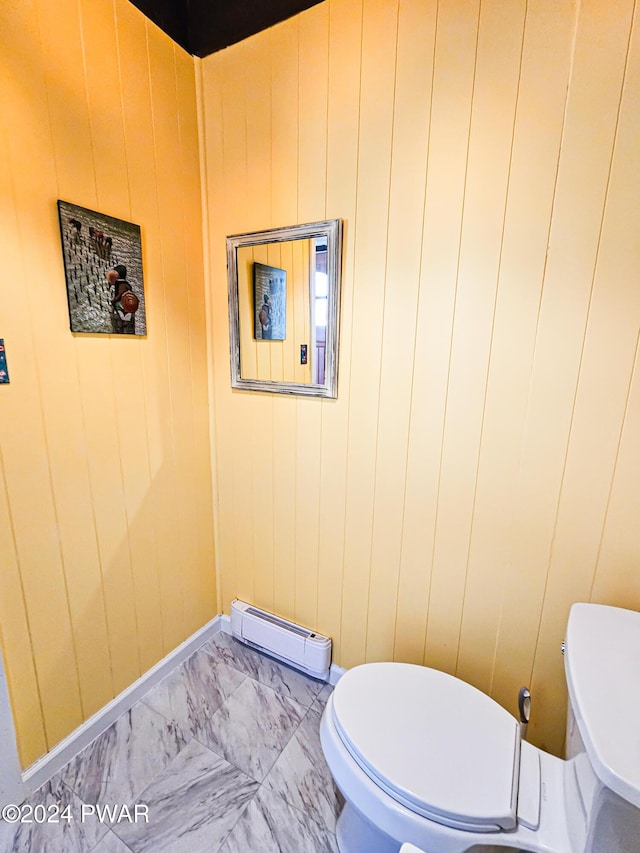 bathroom featuring a baseboard radiator, toilet, and wood walls