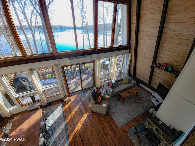 living room featuring a water view, dark hardwood / wood-style floors, and a wall mounted air conditioner