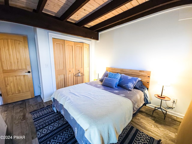 bedroom featuring beamed ceiling, dark hardwood / wood-style flooring, a closet, and wooden ceiling