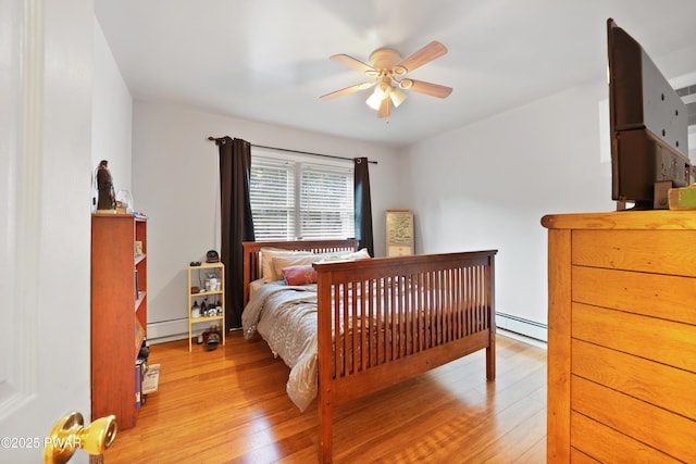 bedroom with ceiling fan, a baseboard heating unit, and light hardwood / wood-style flooring