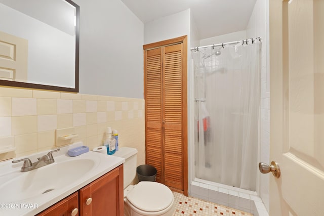 bathroom featuring toilet, vanity, tile walls, tile patterned floors, and a shower with curtain