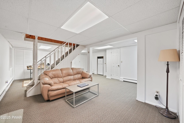 living room with a baseboard heating unit, carpet, and a drop ceiling