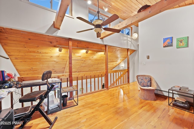 living area with wood ceiling, hardwood / wood-style flooring, ceiling fan, high vaulted ceiling, and beam ceiling