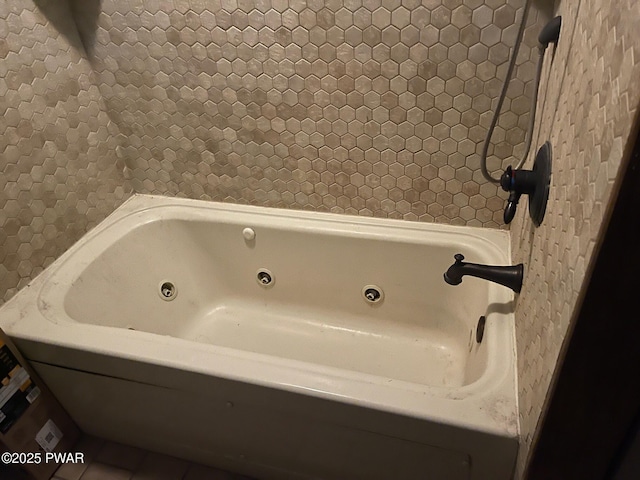 bathroom with a tub to relax in and tile patterned flooring