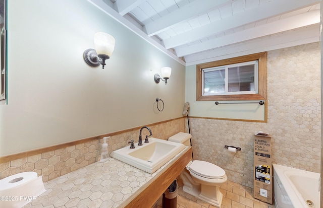 bathroom featuring a tub, toilet, sink, and vaulted ceiling with beams