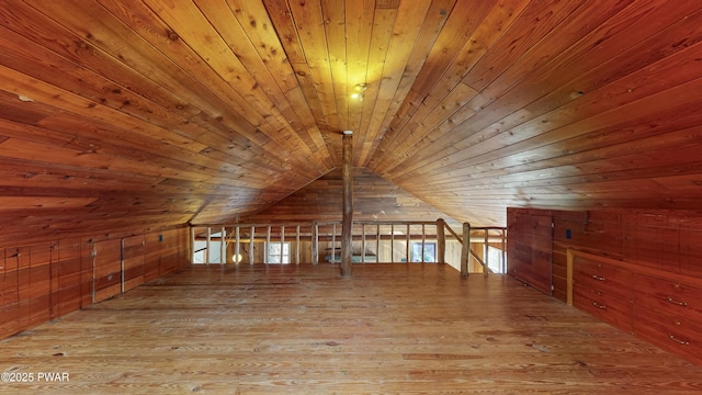 additional living space with wooden walls, vaulted ceiling, light hardwood / wood-style flooring, and wooden ceiling