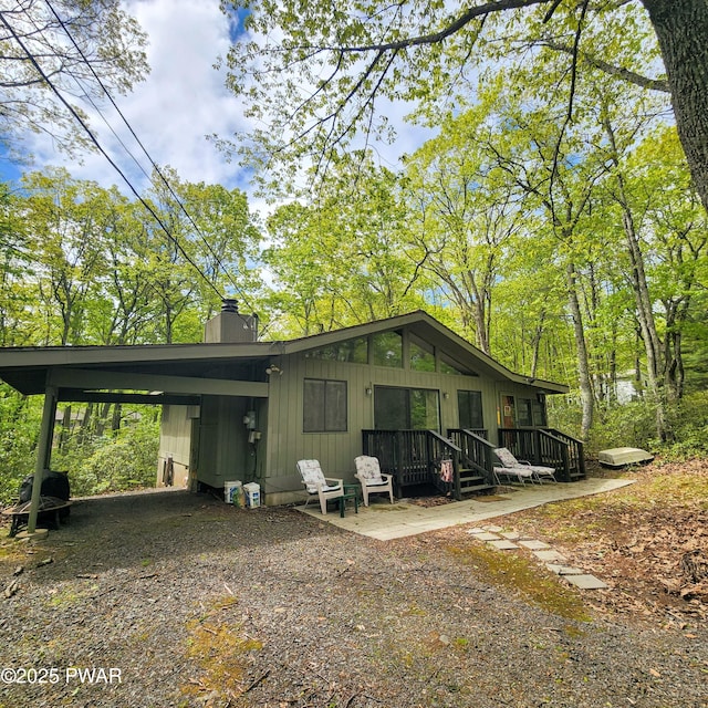 802 Placer Ct, Lords Valley, PA 18428 - view of side of home with a chimney, an attached carport, and driveway