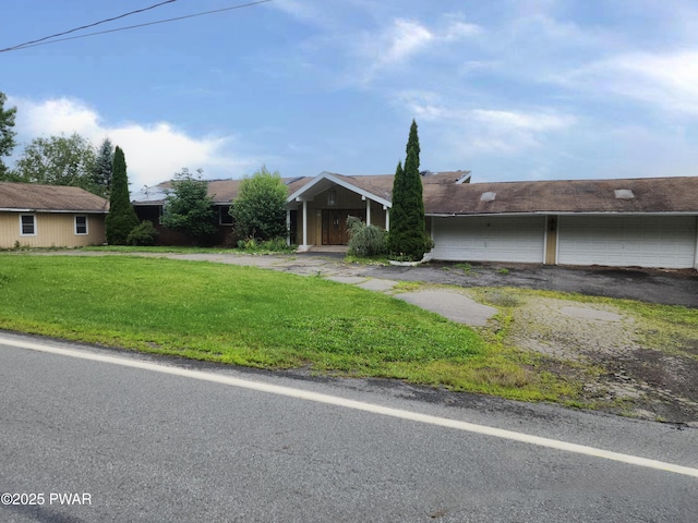 view of front of house with aphalt driveway and a front lawn