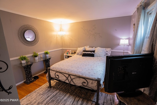 bedroom featuring wood finished floors and crown molding