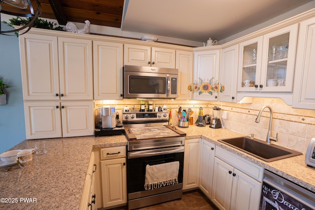 kitchen with tasteful backsplash, stainless steel appliances, a sink, and light countertops