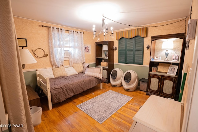 bedroom with a notable chandelier and wood finished floors