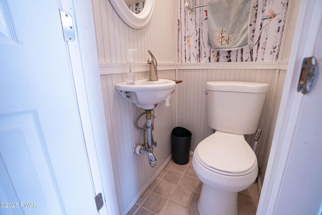 half bathroom featuring toilet and tile patterned floors