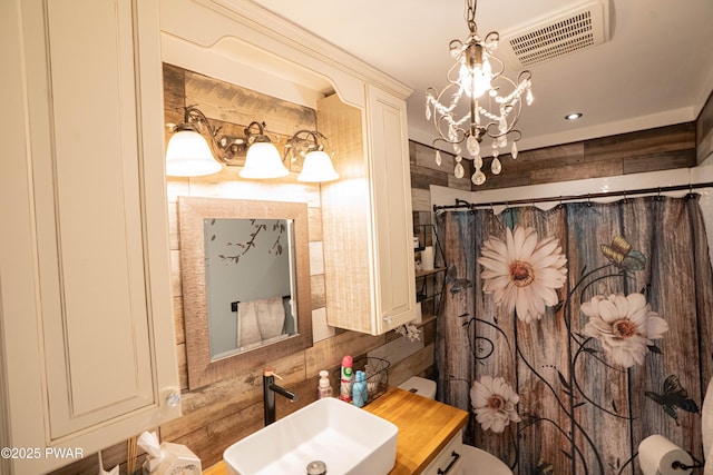 full bathroom featuring visible vents, toilet, an inviting chandelier, a sink, and a shower with curtain