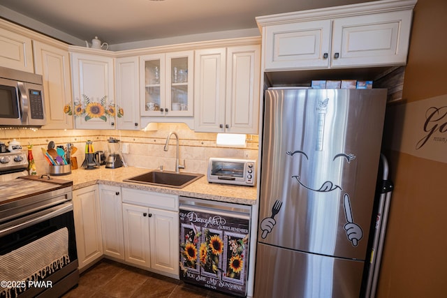 kitchen with appliances with stainless steel finishes, a toaster, a sink, and decorative backsplash