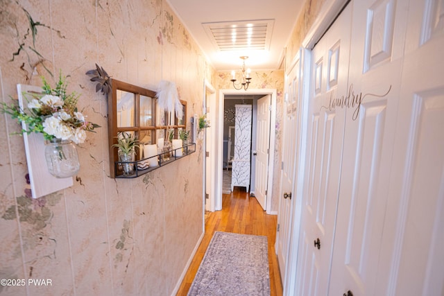 hallway featuring light wood finished floors and visible vents