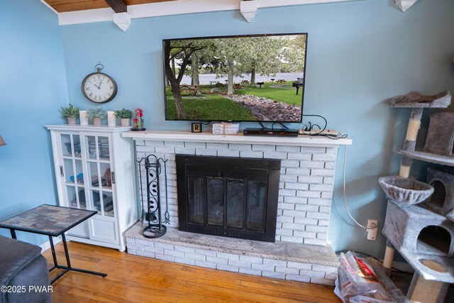 interior details featuring a brick fireplace and wood finished floors