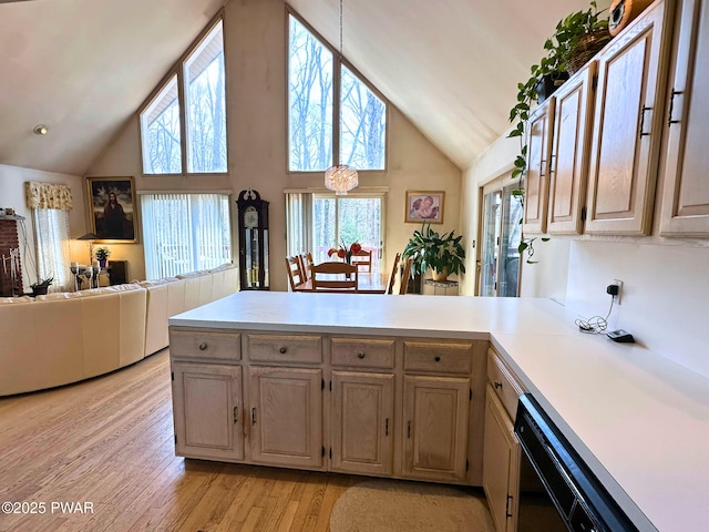 kitchen featuring light wood-style flooring, light countertops, dishwasher, a peninsula, and high vaulted ceiling