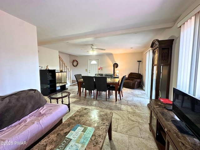 living room featuring stone tile floors, a healthy amount of sunlight, stairs, and ceiling fan