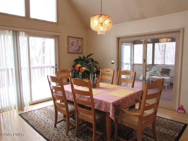 dining space with light wood-style floors and lofted ceiling