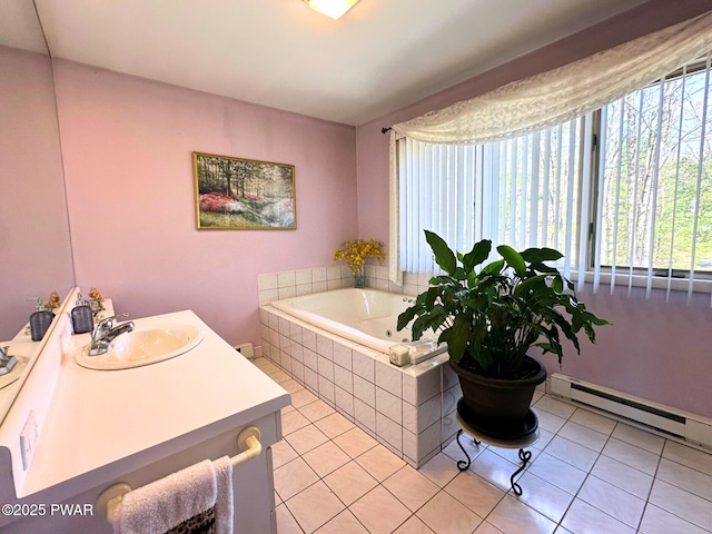 full bath featuring a garden tub, vanity, a baseboard heating unit, and tile patterned flooring