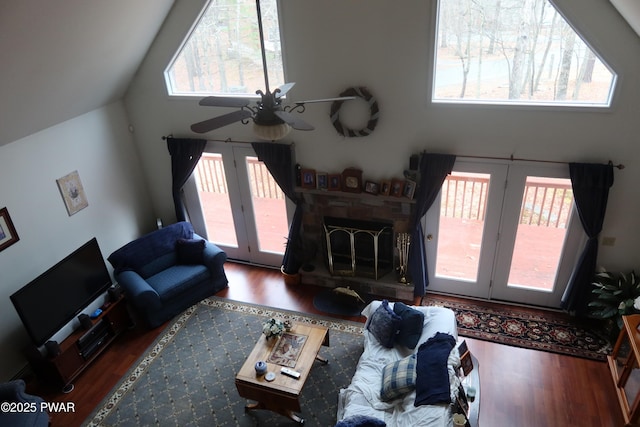 143 Heritage Dr, Lackawaxen, PA 18435 - living room with wood finished floors, high vaulted ceiling, a ceiling fan, a fireplace with raised hearth, and french doors