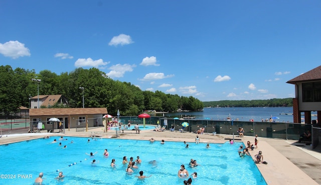 view of swimming pool featuring a water view and a patio